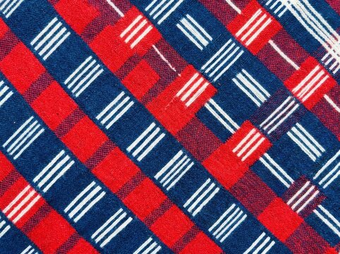 Traditional african kente cloth pattern with red and blue checkered fabric texture and white woven stripes