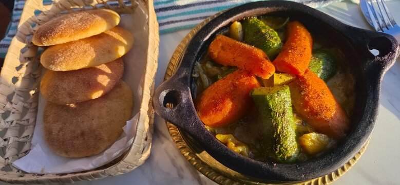 Marokkanische Speise, Gem&uuml;se aus dem marokkanischen  Schmortopf Tajine mit Fladenbrot 