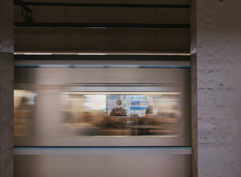 Tokyo, Japan - 04 November 2025: View of a Tokyo Metro Ginza Line train passing through a station with motion blur and a passenger visible inside the carriage.