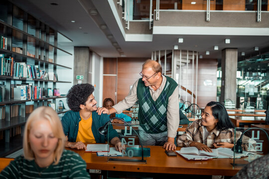 Professor mentoring students in a modern university library