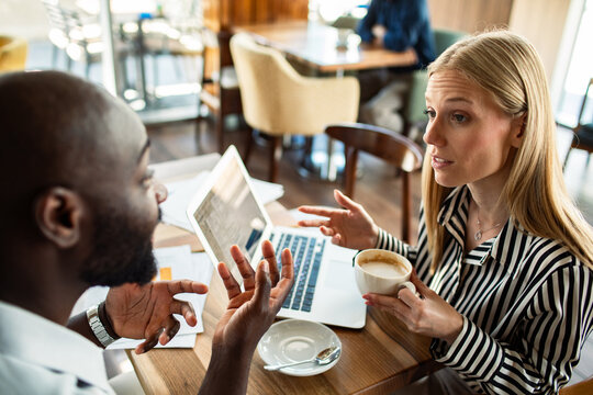 Business colleagues discussing work over coffee in a cafe