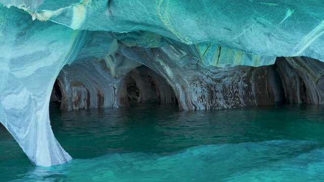 Boat-level view inside the Marble Caves, showcasing smooth water-eroded stone textures and vibrant turquoise glacial water in General Carrera Lake, Patagonia, Chile.