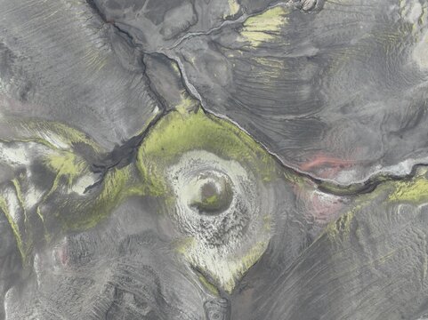 Aerial view of a volcanic crater surrounded by vibrant green moss and dark lava fields in the highlands of Kirkjubaejarklaustur, Skaftarhreppur, Iceland.