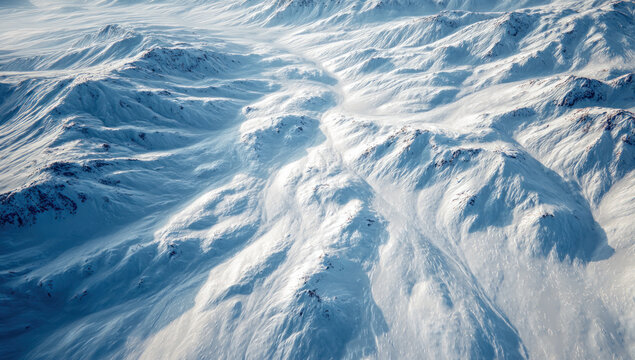 A breathtaking aerial perspective showcasing vast, snow-covered mountain ranges under winter conditions, highlighting nature's grandeur and cold environment.