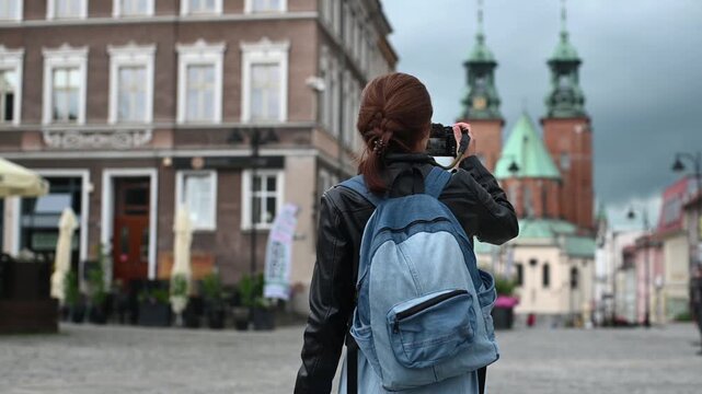 Tourist Woman Photographs Stunning Gniezno Cathedral In Bustling City Center Architecture Scene