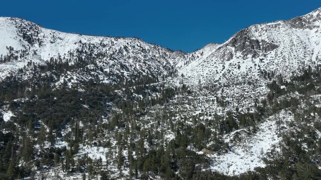 Stunning Aerial Views of Winter Snowy Mountains Back Tilt Up in San Gabriel Mts California USA