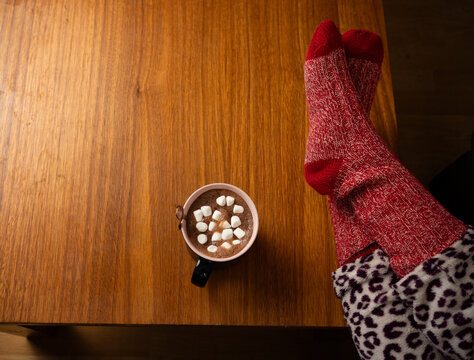 Relaxing at home with a warm beverage hot chocolate mug and comfortable wool socks