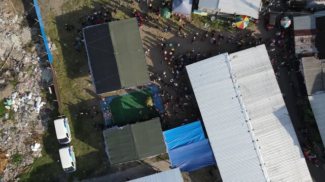 Aerial footage of crowds of people and cultural processions or Javanese traditional festivals, amidst the density of urban villages.