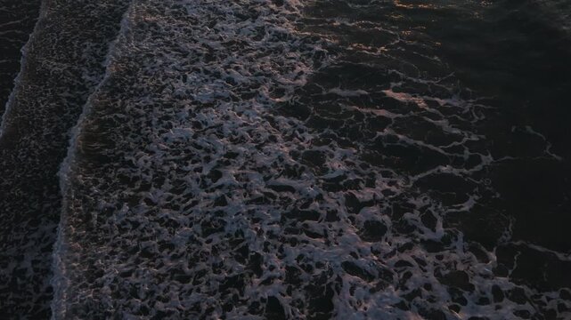 Waves continuously roll onto the sandy beach at Myrtle Beach, South Carolina, highlighting the dynamic movement of water and foam at dusk
