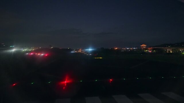滑走路を走る飛行機の車窓から見た夜景