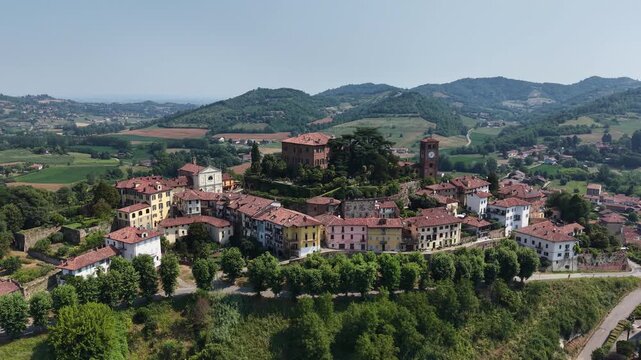 Aerial view of the historic Castello di Casalborgone overlooking the village rooftops, surrounding green hills, and lush landscape in Casalborgone, Piemonte, Italy.