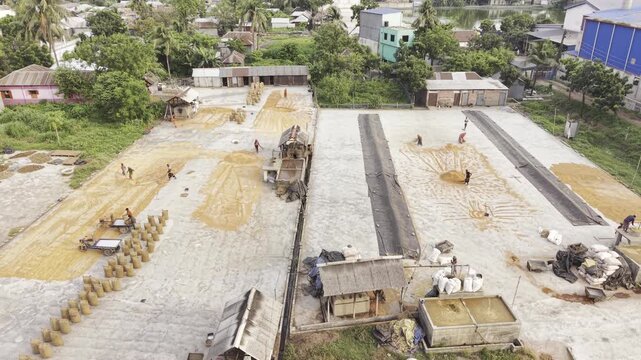 Ascending drone footage of the Khajanagar rice processing factory in Kushtia, Bangladesh, showing factory buildings, warehouses, and industrial infrastructure.