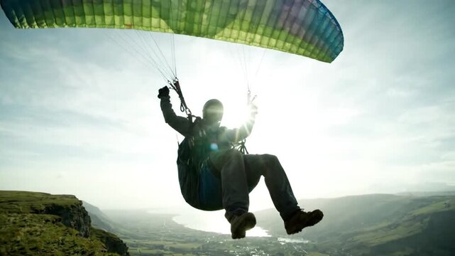 Adventurous person soaring high above scenic landscape during paragliding flight