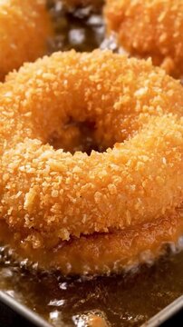 Golden brown Japanese curry bread frying in hot oil with crispy panko breadcrumbs close up