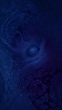 Top view deep blue color ink water background swirling abstract fluid texture swirl vortex art design pattern cosmic fantasy wave motion mystic dreamy night sky effect