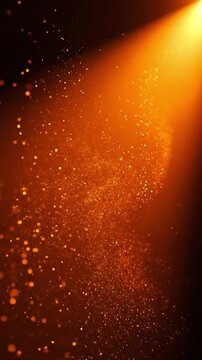 Golden glowing particles floating in warm light beam on dark background for festive events