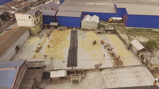 Forward drone footage capturing a large rice processing complex and industrial landscape in Khajanagar, Kushtia, Bangladesh.