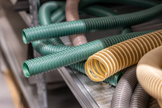 Sections of hoses with reinforced plastic rim on a shelf in a warehouse.