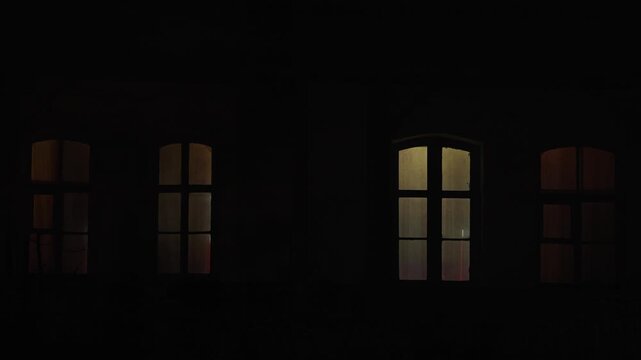 Mystical flickering of light in the windows of houses. Horror mysticism