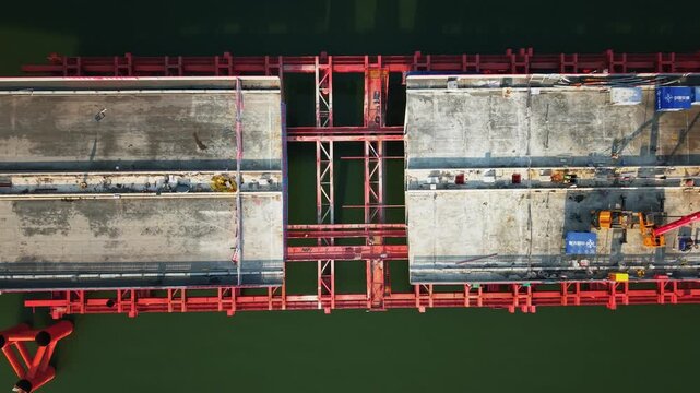 Bridge demolition over river in China; drone view of structure being dismantled during the day