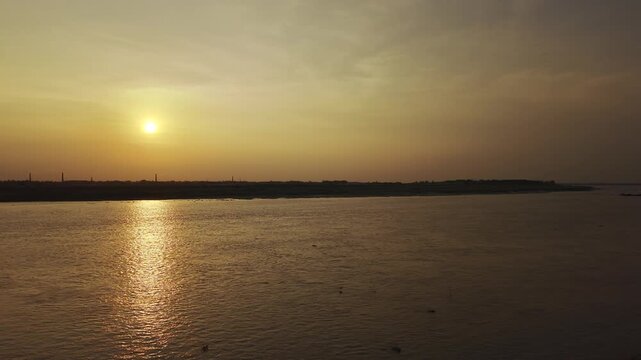 Professional 4K drone footage featuring a slow left camera pan that gradually reveals the setting sun over the Padma&ndash;Gorai River confluence in Kushtia, Bangladesh. 