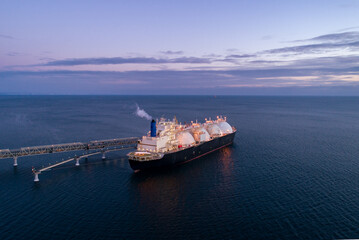 Aerial of Liquified Natural Gas LNG carrier moored to a small gas terminal. Fuel crisis. Sanctions © Evgenii Bakhchev
