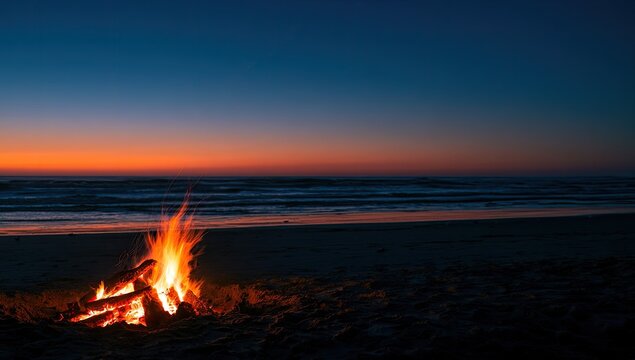 A crackling campfire on a sandy beach at twilight with ocean waves crashing