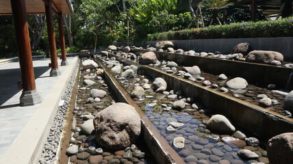 open garden design behind the house using real river stones and a gurgling water flow © Vicky