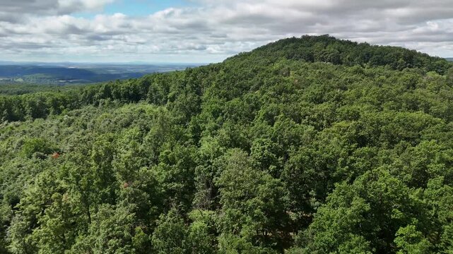 Aerial view of the lush green forests of Bohunicky Rohac in the Stiavnicke Vrchy mountains under a cloudy sky in Levice, Nitra Region, Slovakia.