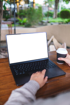 Vertical mockup image of a woman working and touching on laptop computer touchpad with blank white desktop screen in cafe