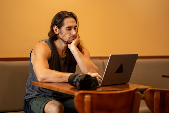 Tired man working on laptop at cafe