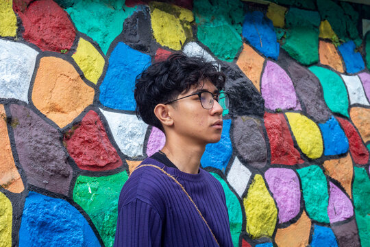 a young man wearing glasses with colorfull backgorund at "colorfull" Village Malang