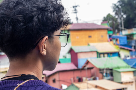 a young man with glasses accessoriesin the "colorful" village of Malang