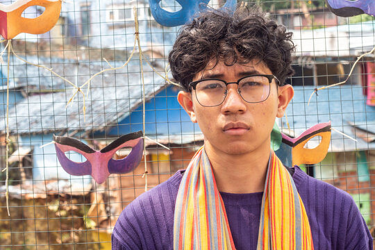 a young man  wearing ethnic scraf and glasses at "colorful" Village of Malang