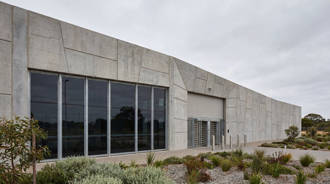 Imposing exterior concrete facade featuring heavy secure window glazing at modern high security prison entrance