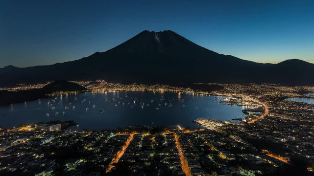 Stunning Atitlan volcano view over night city lights by the lake