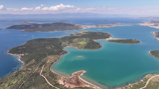 Aerial view of the scenic coastal islands, lush green hills, and turquoise waters of the Aegean Sea in Ayvalik, Balikesir, Turkiye.