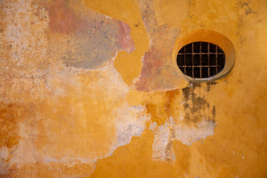 Round window in an orange wall in the Palace of the Inquisition, in the Old Town, in Cartagena, Colombia