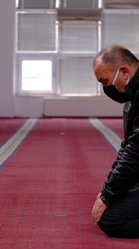 Man With a Mask on His Face Finishes his Prayer
