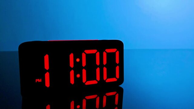 Digital alarm clock changing from 10:59 pm to 11:00 pm with red led display