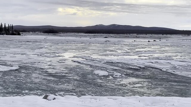 Water and ice flowing in the Delta River on an autumn day in interior Alaska. 