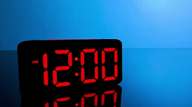 Digital alarm clock changing from 11:59 pm to 12:00 am with red led display