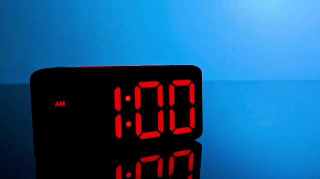 Digital alarm clock changing from 12:59 am to 1:00 am with red led display
