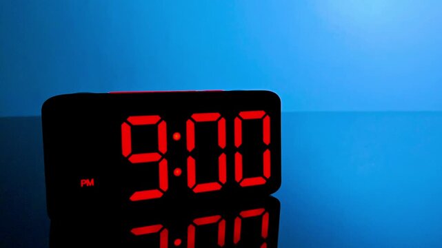 Digital alarm clock changing from 8:59 pm to 9:00 pm with red led display