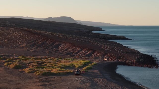 Enjoy camping on the beach as the sun sets while traveling in an suv and teardrop camper in Baja California Mexico