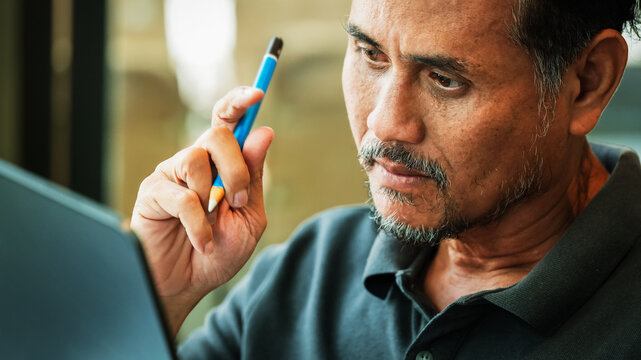 Focused Senior Businessman Thinking While Working on Laptop
