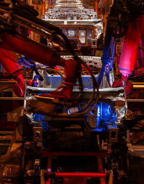 Robotic arms are welding points on the car body on an automated production line.