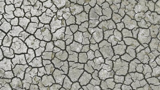 High-quality 4K top-down drone footage of cracked dry earth in a dried lake bed in Bangladesh. The aerial perspective captures extreme drought conditions, water shortages, and climate change.