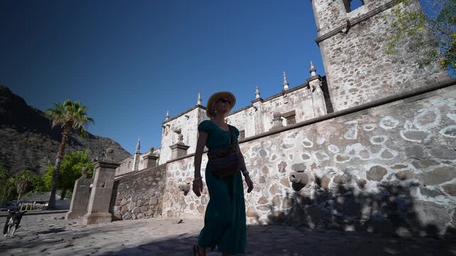 Mature woman smiles and explores San Javier Mission near Loreto at sunrise in Baja California Sur, Mexico
