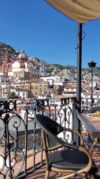 View of the Santa Prisca Church surrounded by colonial white buildings on a hillside in Taxco, Guerrero, Mexico.